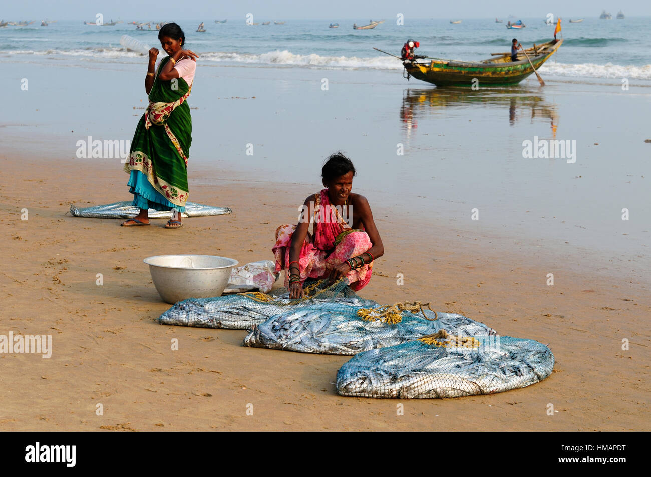 Il Puri, India - 19 dicembre: Indiano vestito con il sari smistare pesce da reti da pesca sulla spiaggia in Orissa, Puri nel dicembre 19, 2009 Foto Stock