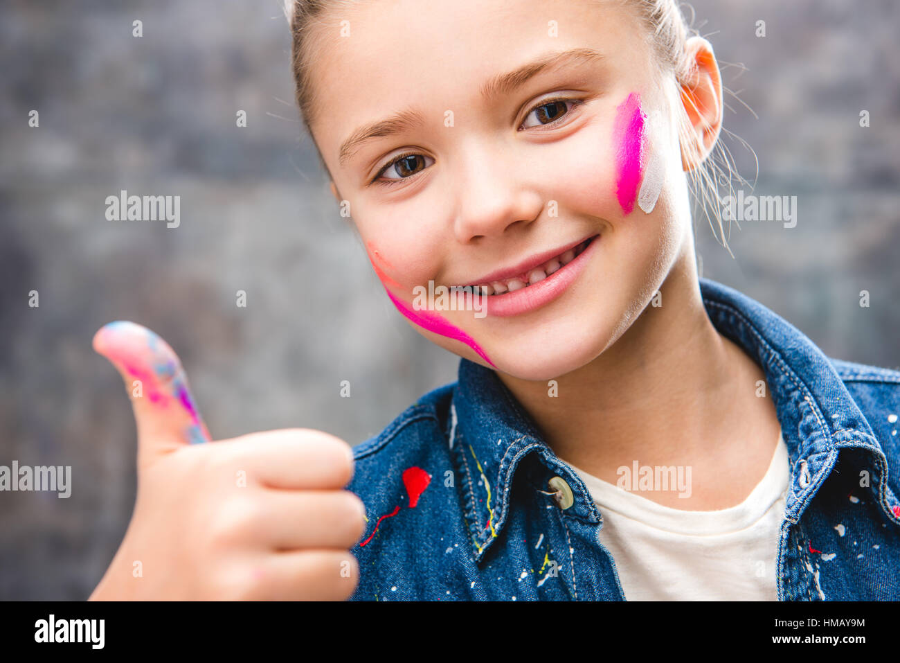 Schoolgirl artista con faccia dipinta Foto Stock