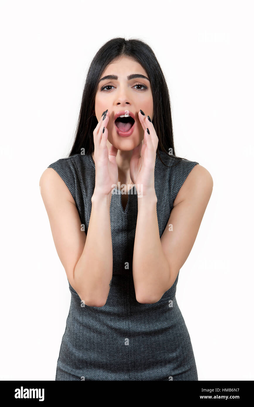 Giovane donna, che indossa un abito grigio è guardando la telecamera e gridando. Foto Stock