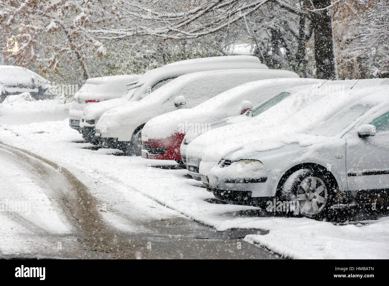 Coperta di neve sulle vetture di parcheggi durante la nevicata. Foto Stock