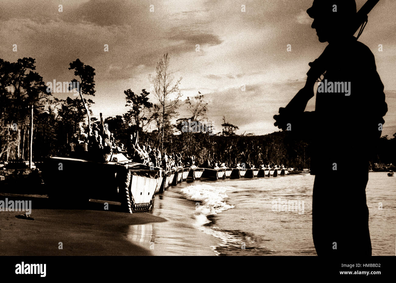"Bufalo d'acqua" (anfibi serbatoi) line up per invasione di Cape Sansapor all'estremità occidentale di Olandesi Nuova Guinea. In silhouette, Coast Guardsman Robert Campbell sta di guardia. Ca. 1944. (Coast Guard) Data esatta Shot NARA sconosciuto file #: 026-G-2840 guerra & CONFLITTO PRENOTA #: 858 Foto Stock