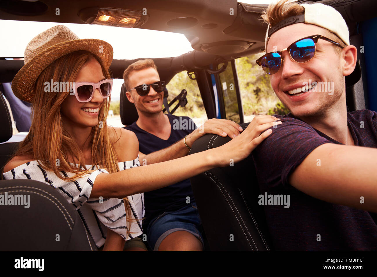 Gruppo di amici la guida Open Top auto sulla strada di campagna Foto Stock