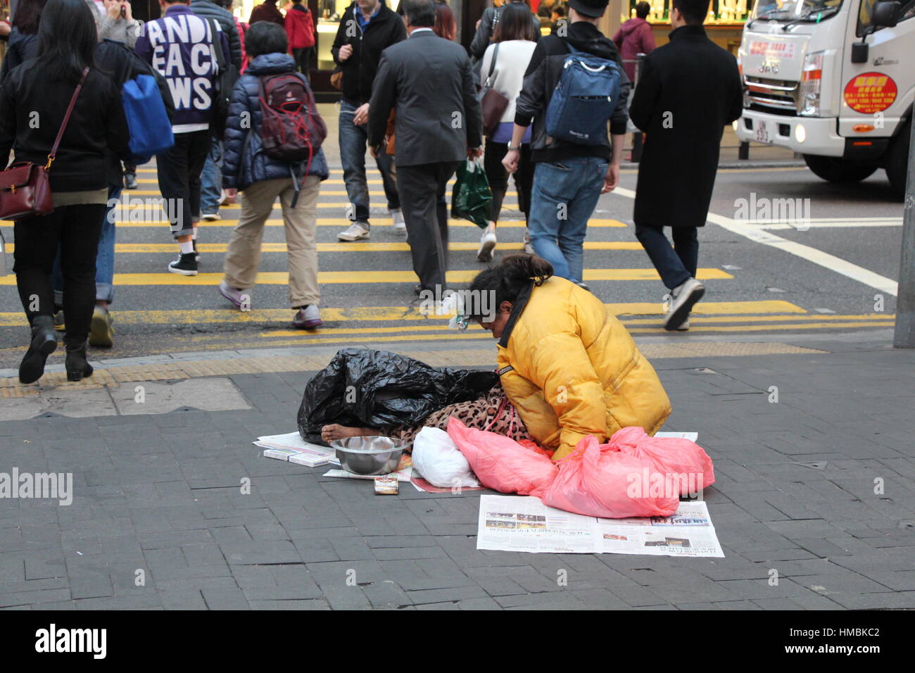 Beggar-donna con sacchetti di plastica su Hong Kong il distretto centrale degli affari Foto Stock