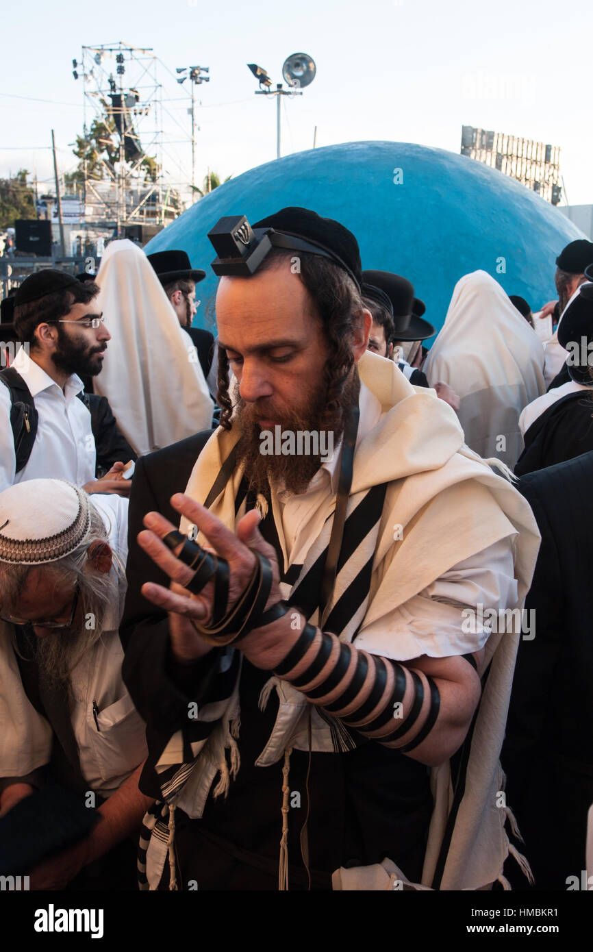 MERON, Israele - 18 Maggio 2014: un ebreo ortodosso mettendo sul suo tefillin, vicino alla tomba del Rabbino Shimon, all'annuale hillulah del Rabbino Shimon bar Yocha Foto Stock