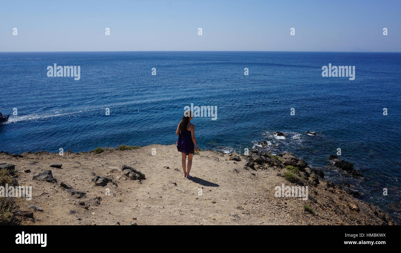 Donna che guarda all'orizzonte di Santorini con vista sul mare a Red Beach Santorini Foto Stock