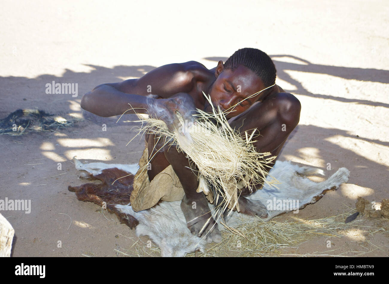 Un giovane uomo Damara mostra come accendere un fuoco Foto Stock