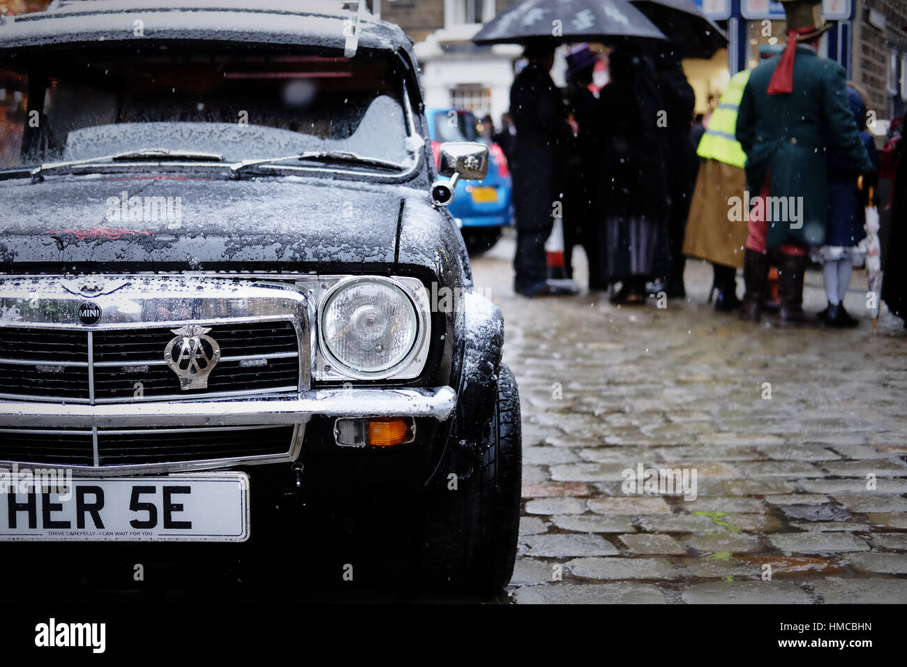 Un classico Mini Clubman station wagon convertito a guardare come un funebre su una strada a ciottoli nella neve a un evento steampunk. Foto Stock