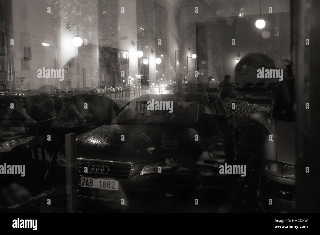 Praga, Repubblica Ceca - 18 novembre 2014: la riflessione di persone che parlano e luci su una finestra della barra di Cafe e liberali e auto su una strada di notte Foto Stock