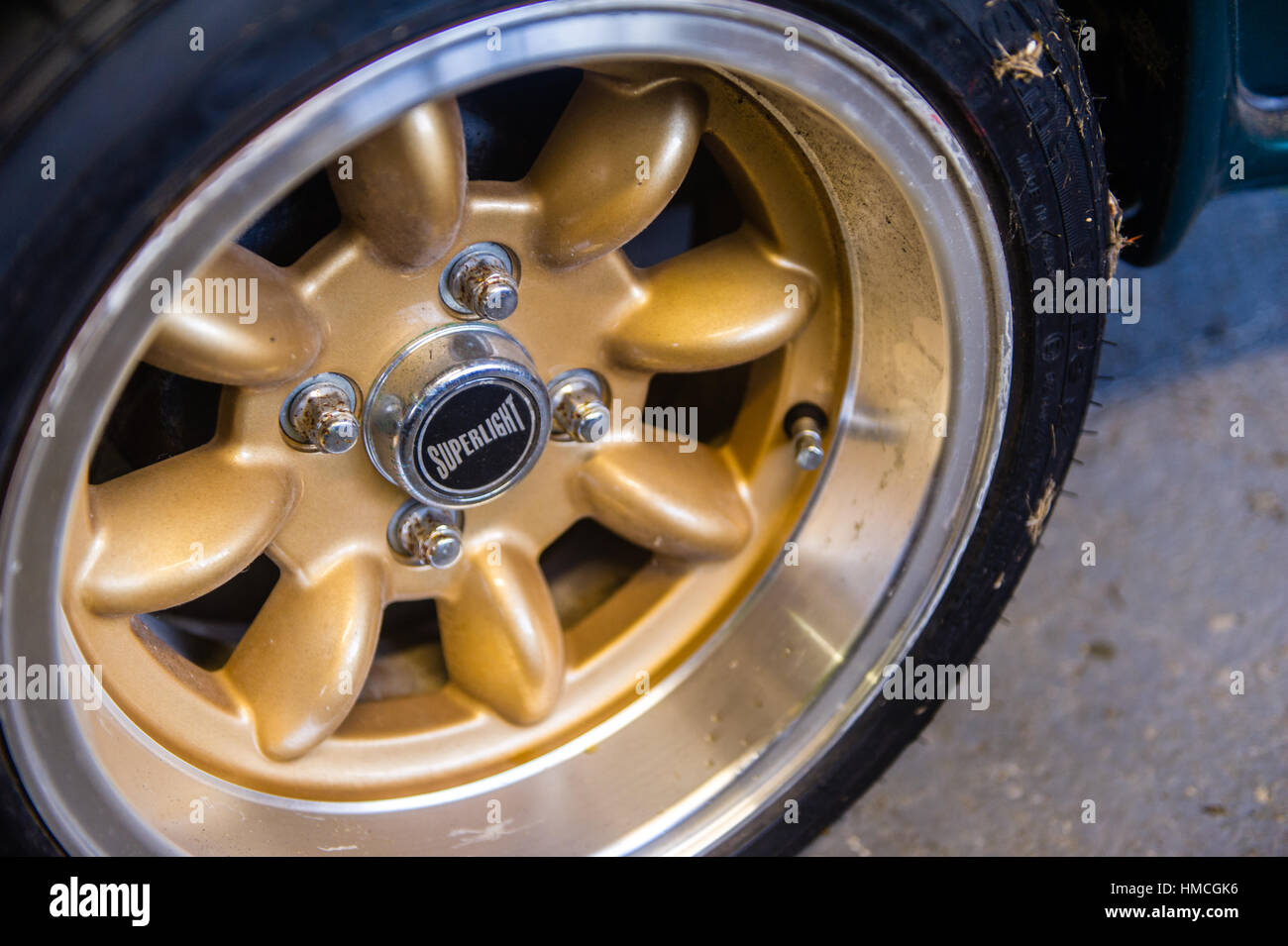 Cerchio in lega con il pneumatico su un classico Austin Mini Cooper in un garage interno. Foto Stock