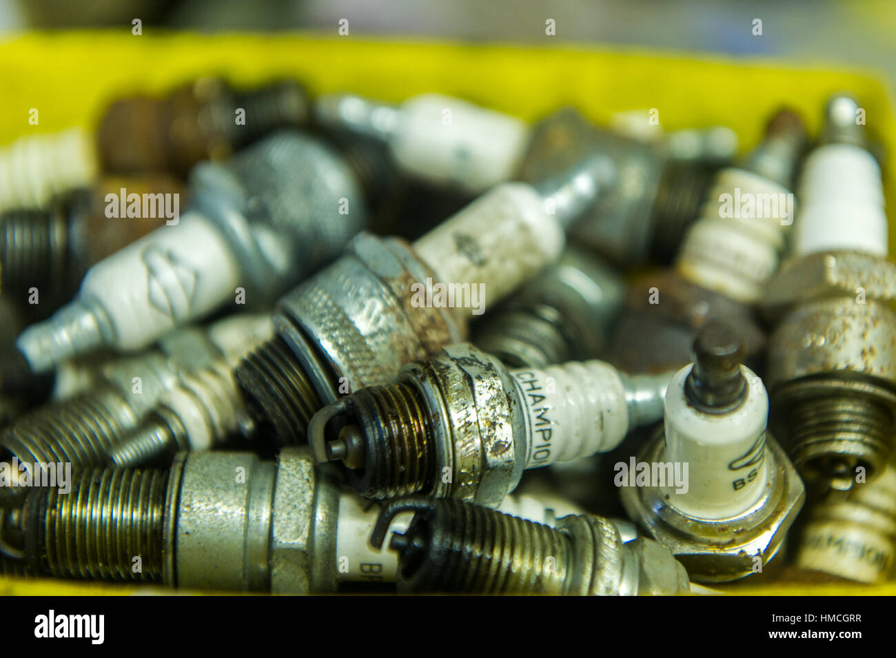 Contenitore pieno di usato candele per auto. Foto Stock