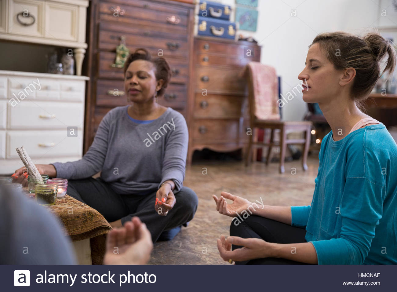 Serena donna seduta nella posizione del loto in classe di meditazione Foto Stock