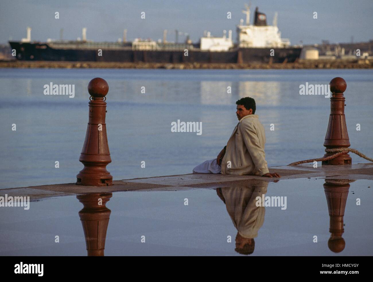 Un uomo seduto al porto di Arzew, Algeria. Foto Stock