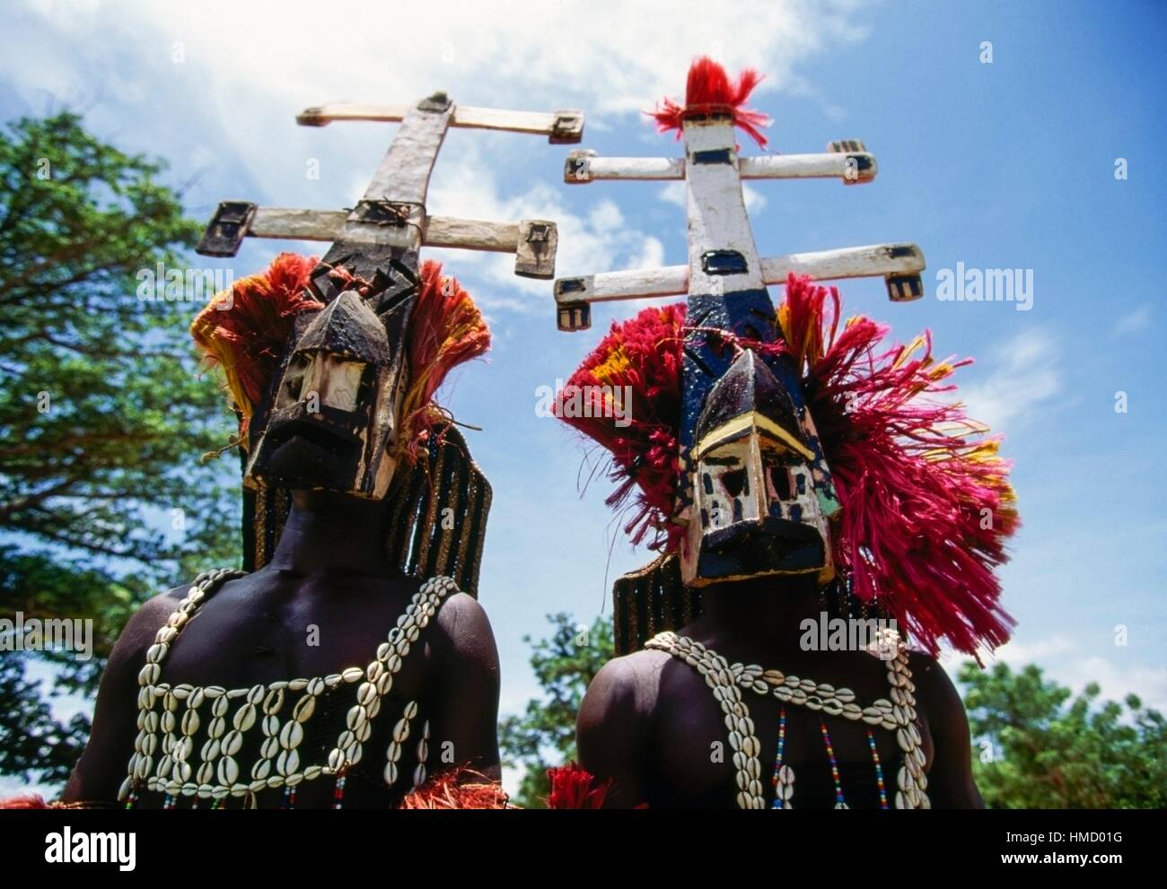 Danzatori Dogon, uno di essi su palafitte, indossando maschere Kanaga eseguendo la Dama o mascherato danza funebre, Bandiagara scarpata, Foto Stock