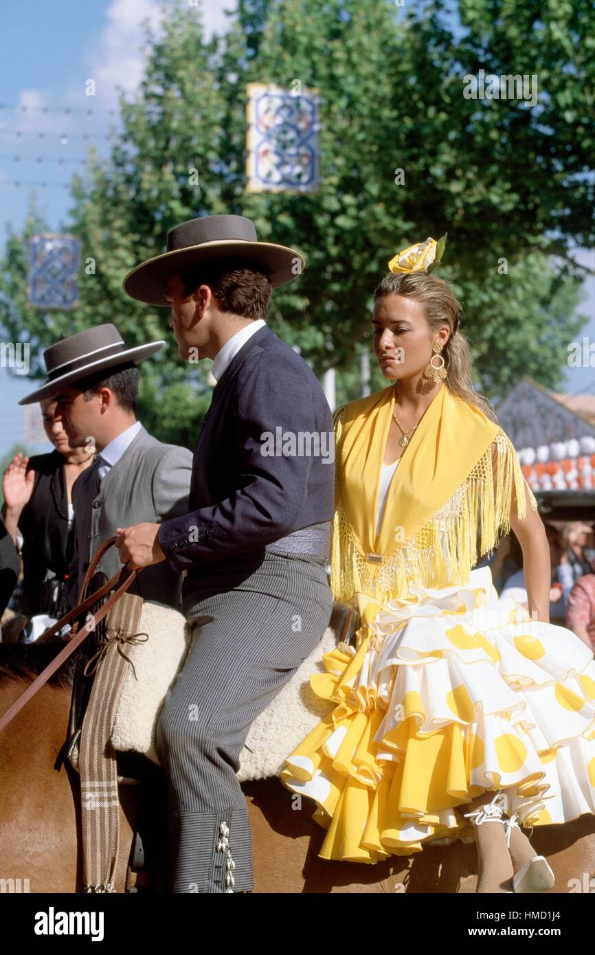 Un uomo e una donna a cavallo in costume tradizionale, la Feria de Abril (fiera di aprile), Siviglia, Andalusia, Spagna. Foto Stock