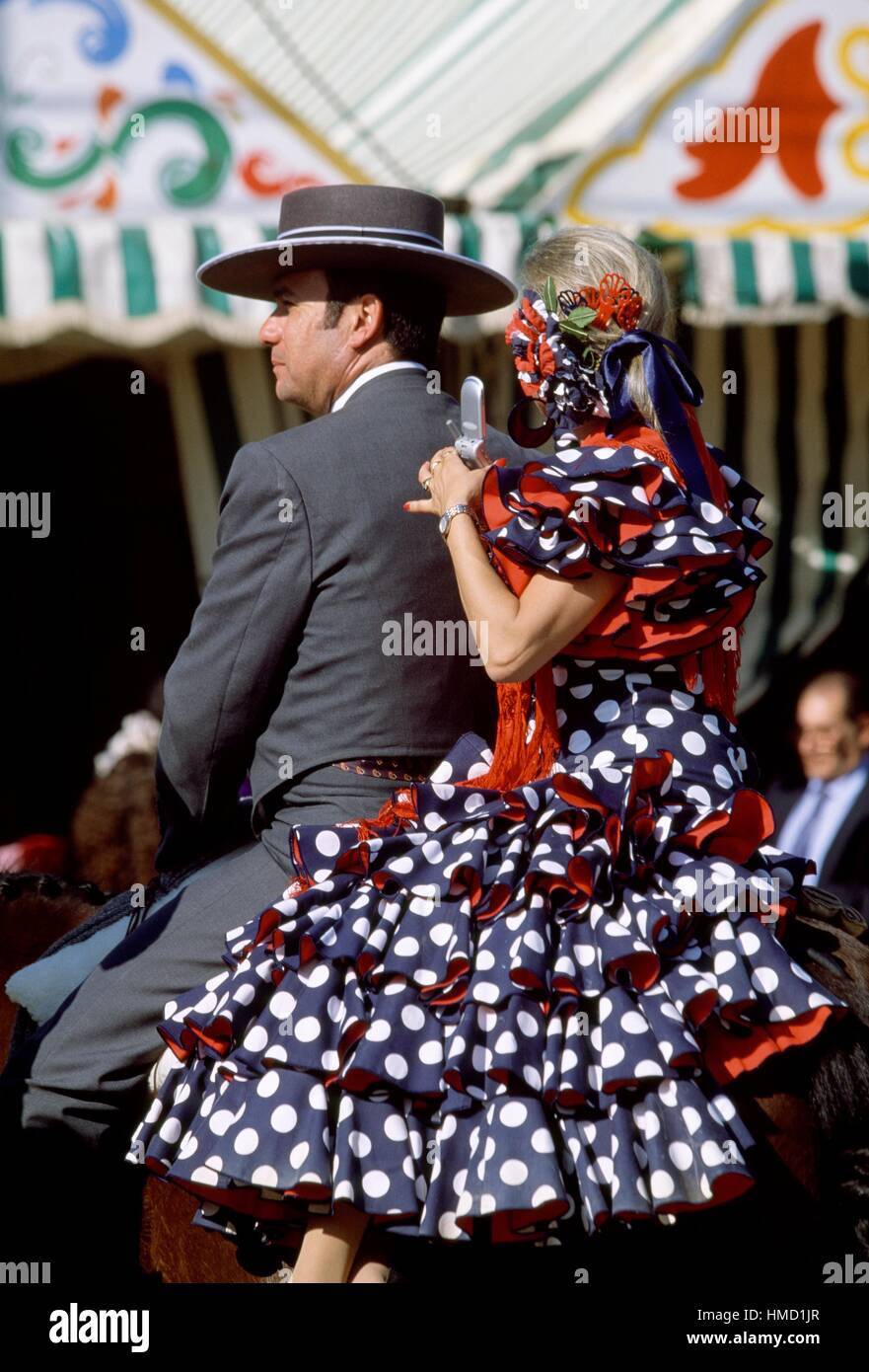 L uomo e la donna in costumi tradizionali a cavallo presso la Feria de Abril (fiera di aprile), Siviglia, Andalusia, Spagna. Foto Stock
