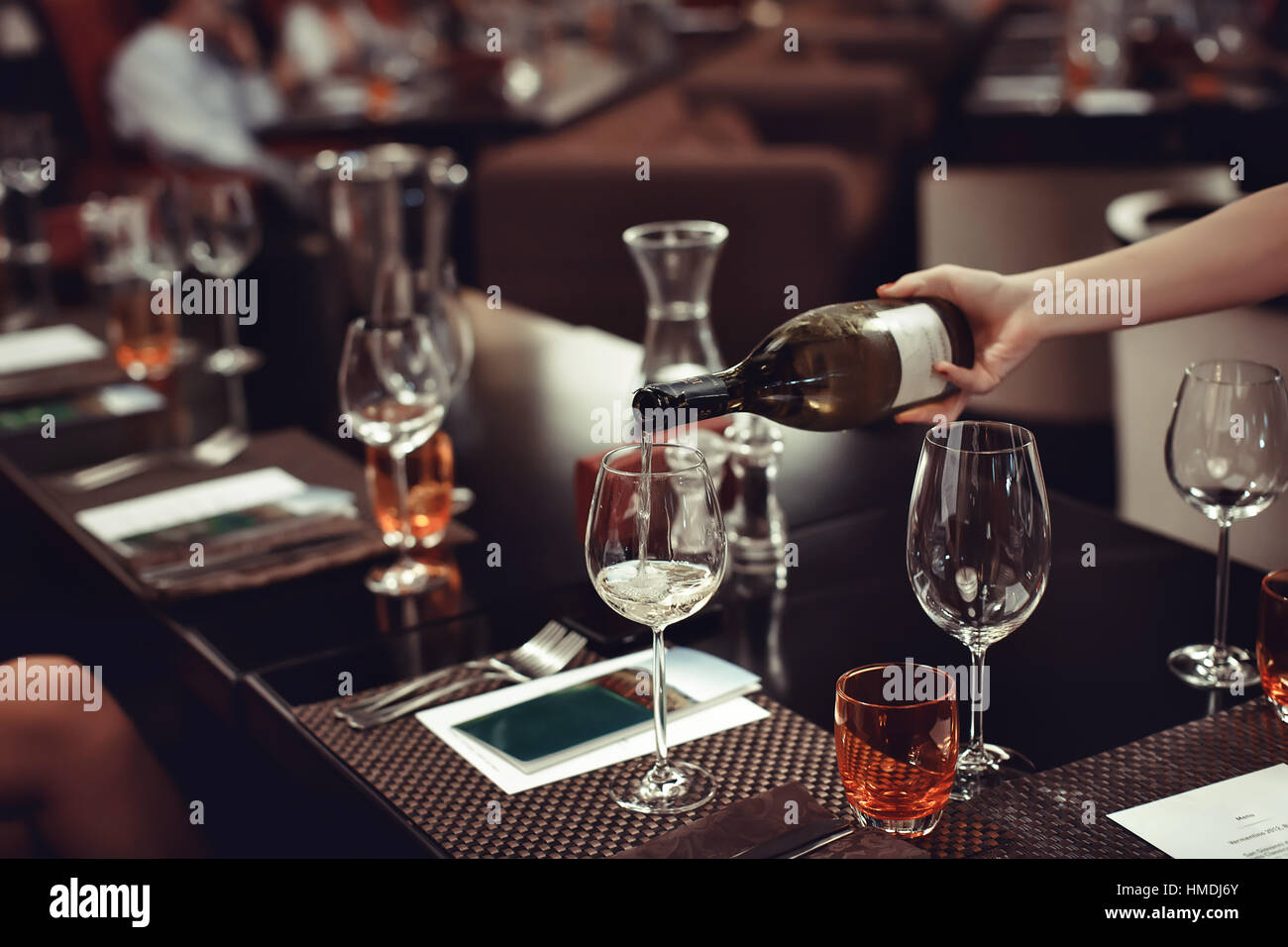 Cameriere versando il vino al bicchiere sullato tabella Foto Stock