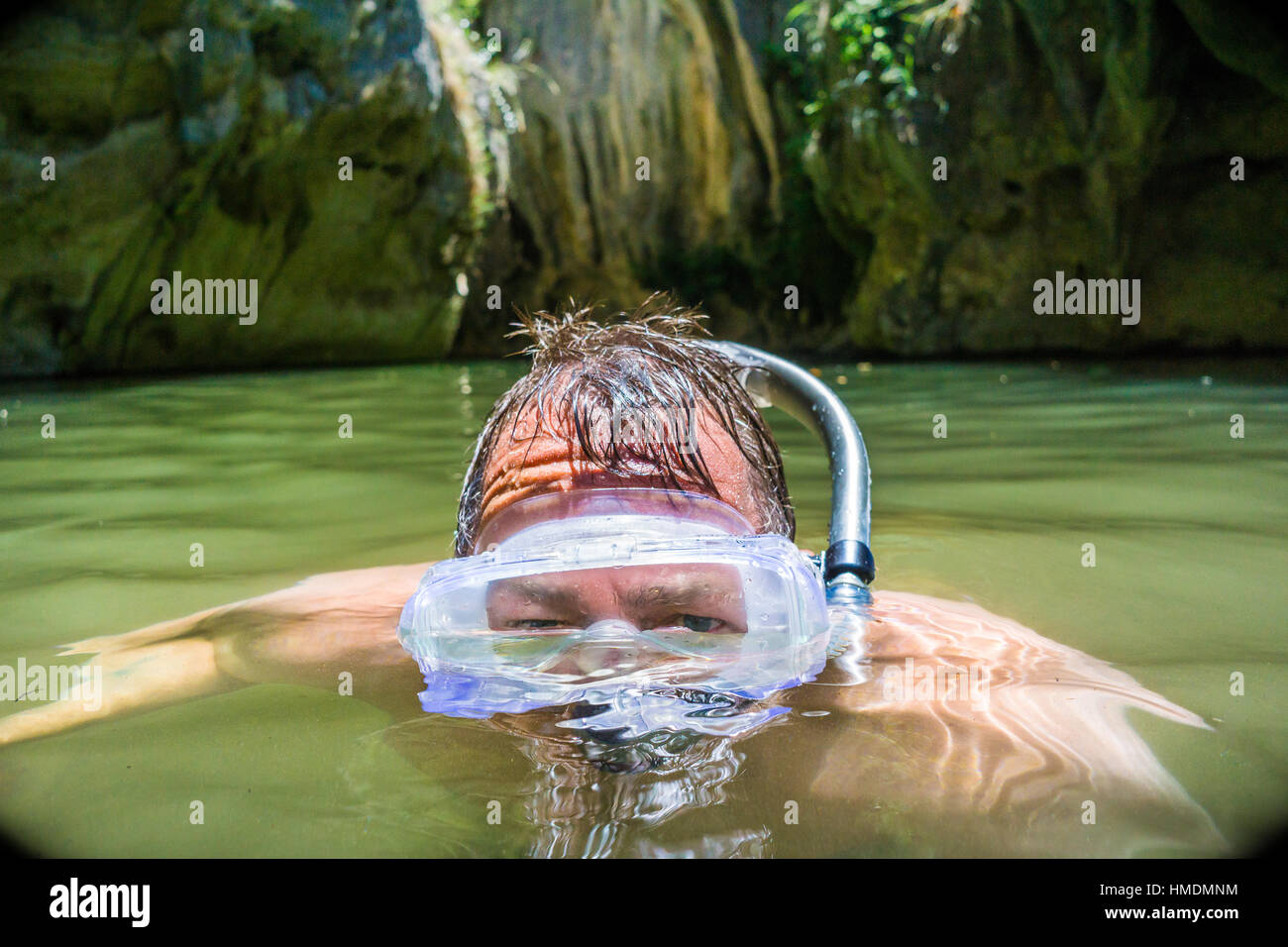 Un uomo di mezza età snorkeling in una piscina naturale Foto Stock