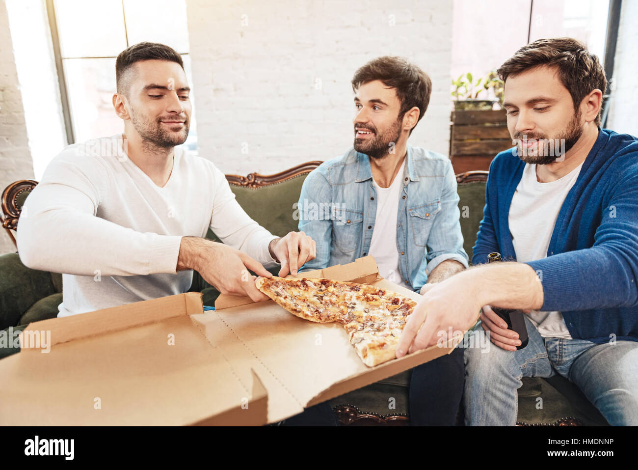 Maschio piacevole gli amici condividono una pizza Foto Stock