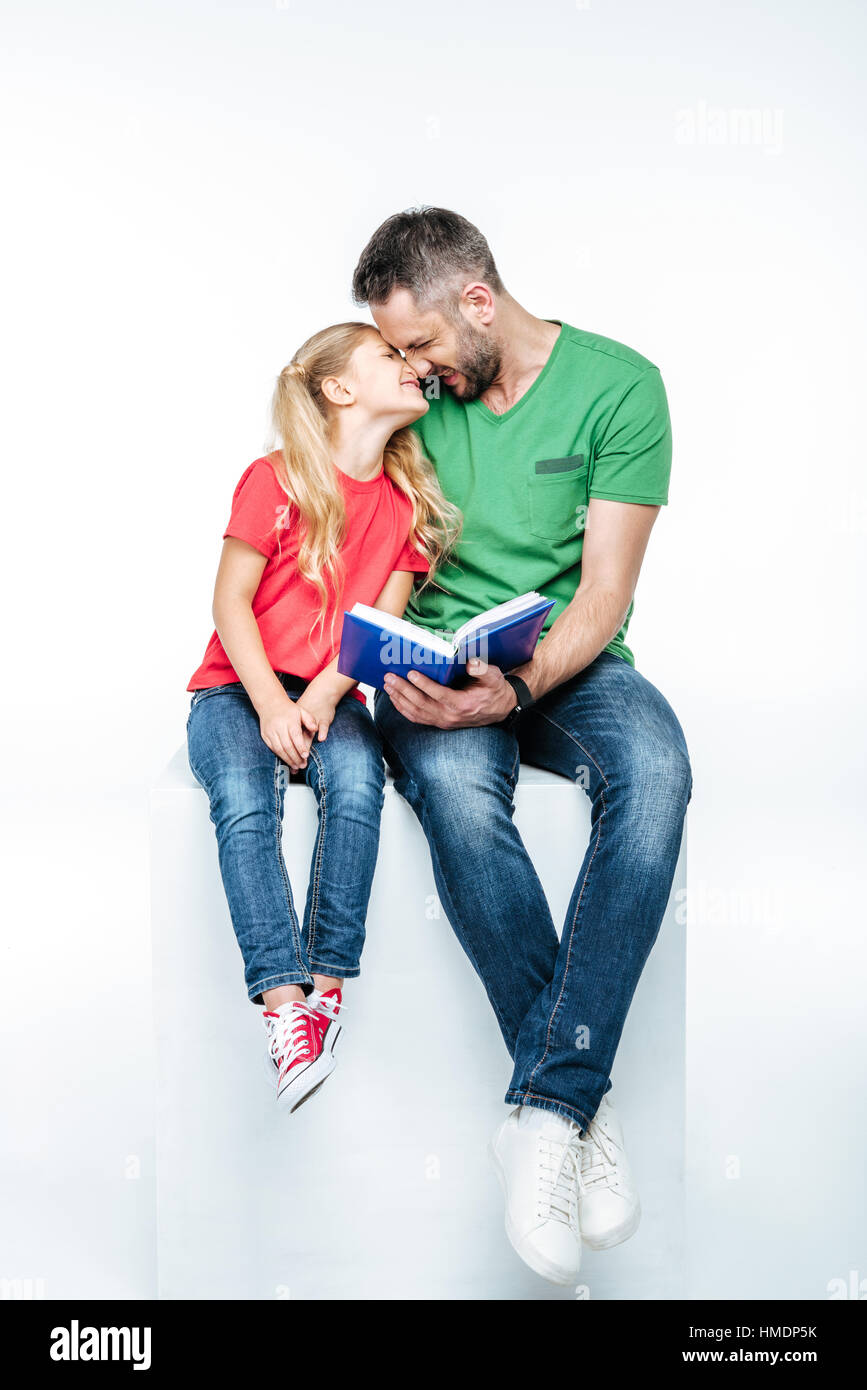 Padre e figlia seduto con libro Foto Stock