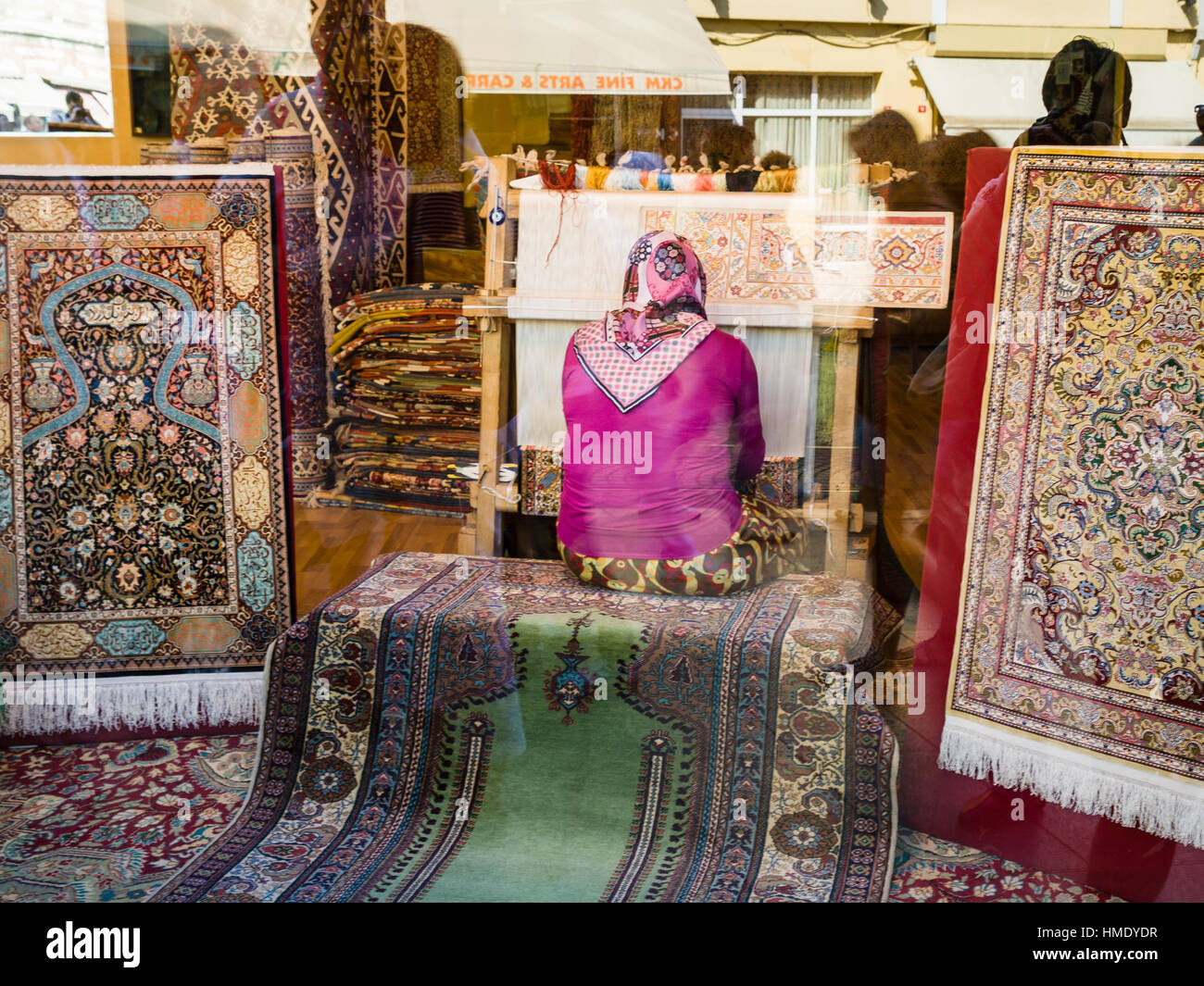 ISTANBUL, Turchia - 10 settembre 2010: Donna tessono tappeti nella finestra del negozio. La tessitura dei tappeti è uno degli antichi mestieri in Turchia, e tradizionalmente Foto Stock