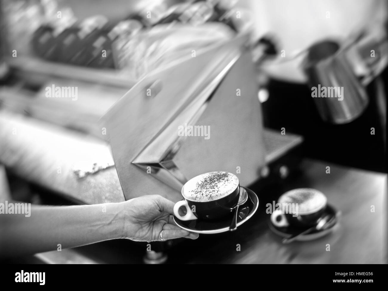 Barista e cameriere che serve cappucinos da uno stile retrò macchina espresso Foto Stock