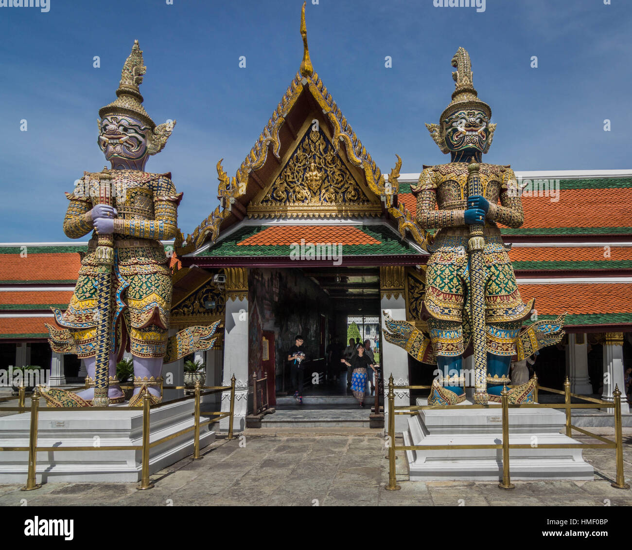 Custode statue guardando oltre il Phra Wiharn Yod e il mausoleo reale in Wat Phra Kaew, a Bangkok (Thailandia) Foto Stock