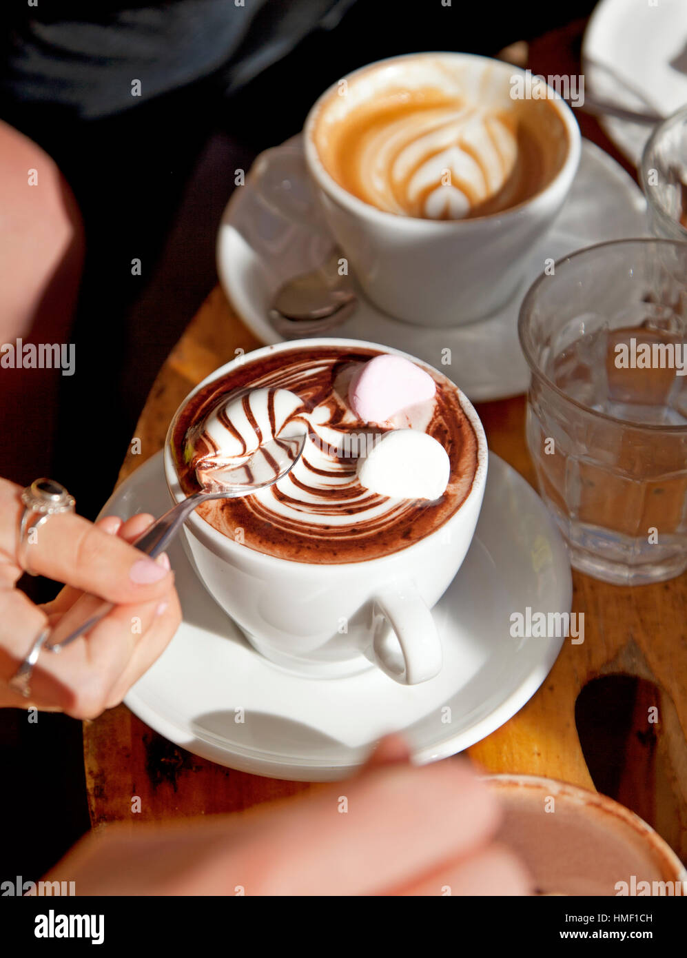 Una tazza di roteato il cioccolato caldo e marshmallows su un rustico tavolo del bar Foto Stock