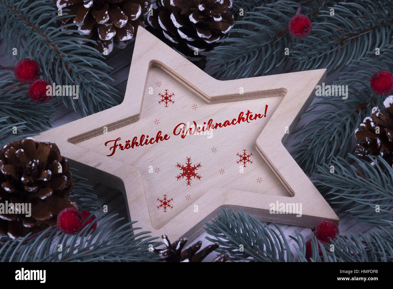 Natale Xmas Anno Nuovo messaggio di saluto festivo card con legno stella a cinque punte rami d abete coni e testo in Germania Foto Stock