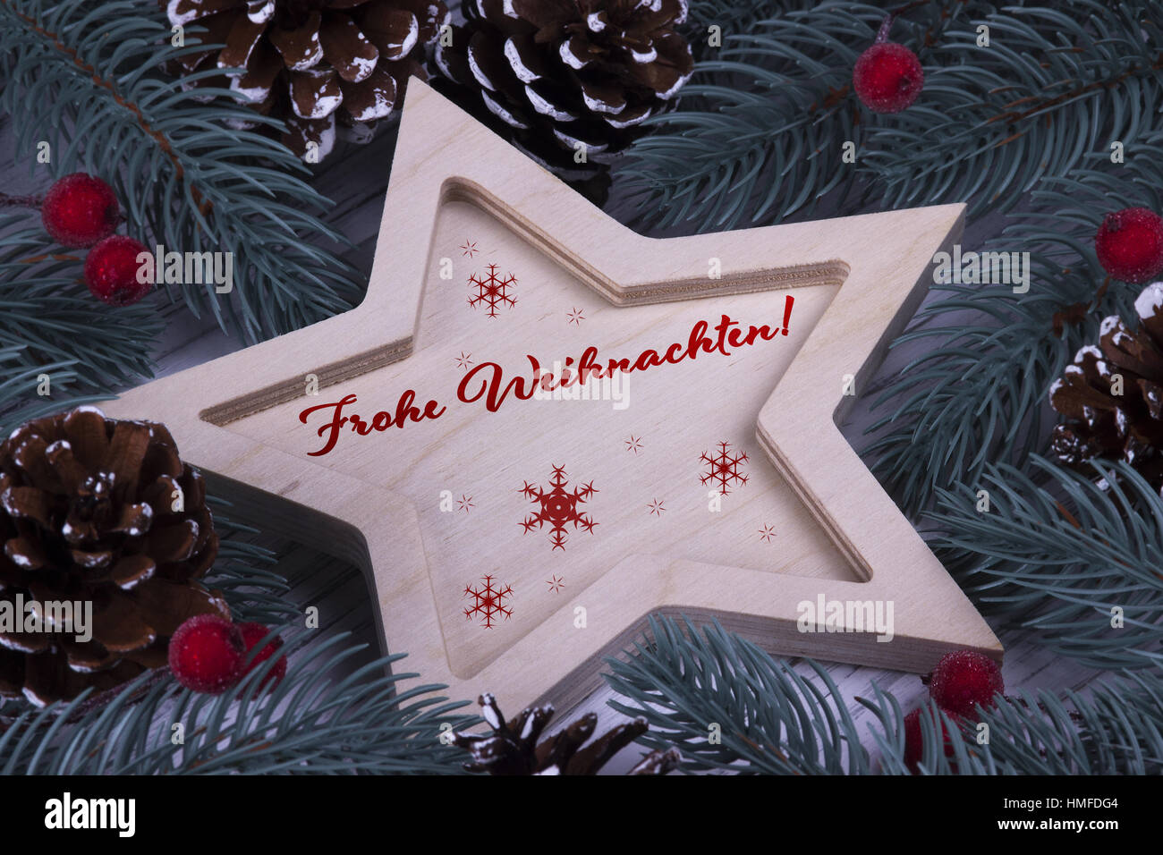 Natale Xmas Anno Nuovo messaggio di saluto festivo card con legno stella a cinque punte rami d abete coni e testo Frohe Weihnachten Foto Stock