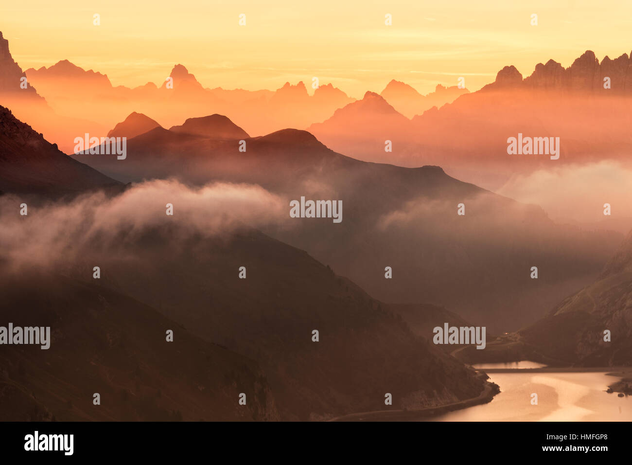 Orange Sky all'alba e la nebbia sulle vette delle Dolomiti e Passo Fedaia, Cima Belvedere, la Val di Fassa Trentino Alto Adige, Italia Foto Stock