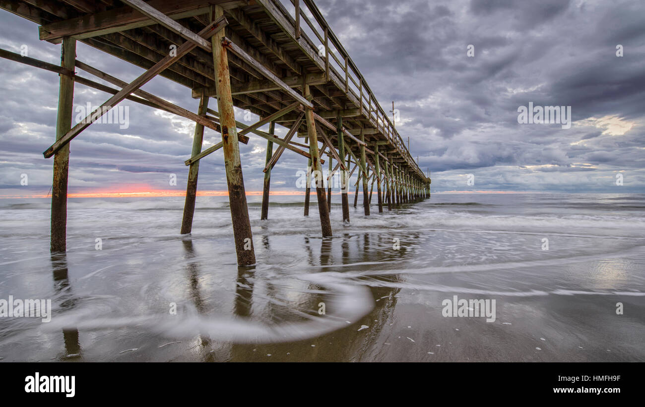 Sulla spiaggia, sull'oceano onde e dal molo presso sunrise, Sunset Beach, North Carolina, Stati Uniti d'America, America del Nord Foto Stock