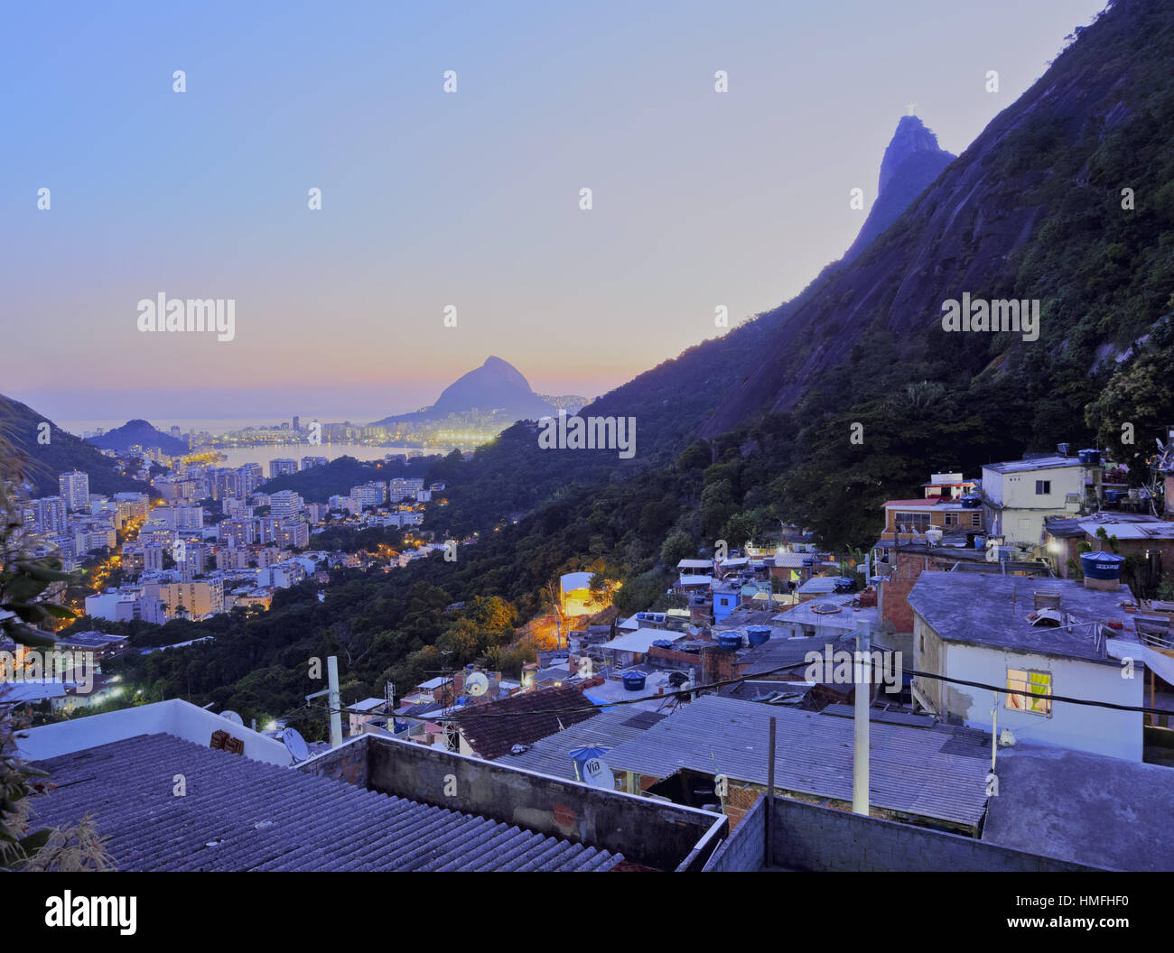 Twilight vista della Favela di Santa Marta con il Corcovado e la statua di Cristo dietro, Rio de Janeiro, Brasile, Sud America Foto Stock