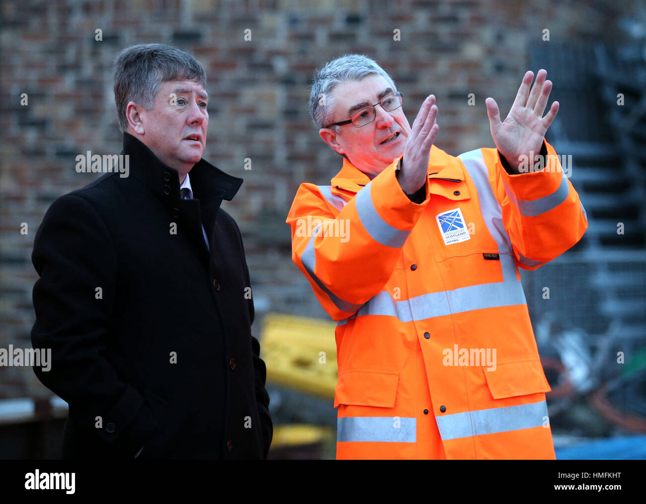 Keith Brown economia Segretario (sinistra) con David Climie direttore del progetto di trasporto dalla Scozia come l'ultimo ponte pezzo di Queensferry incrocio si siede su una chiatta prima che sia sollevata in posizione. Foto Stock