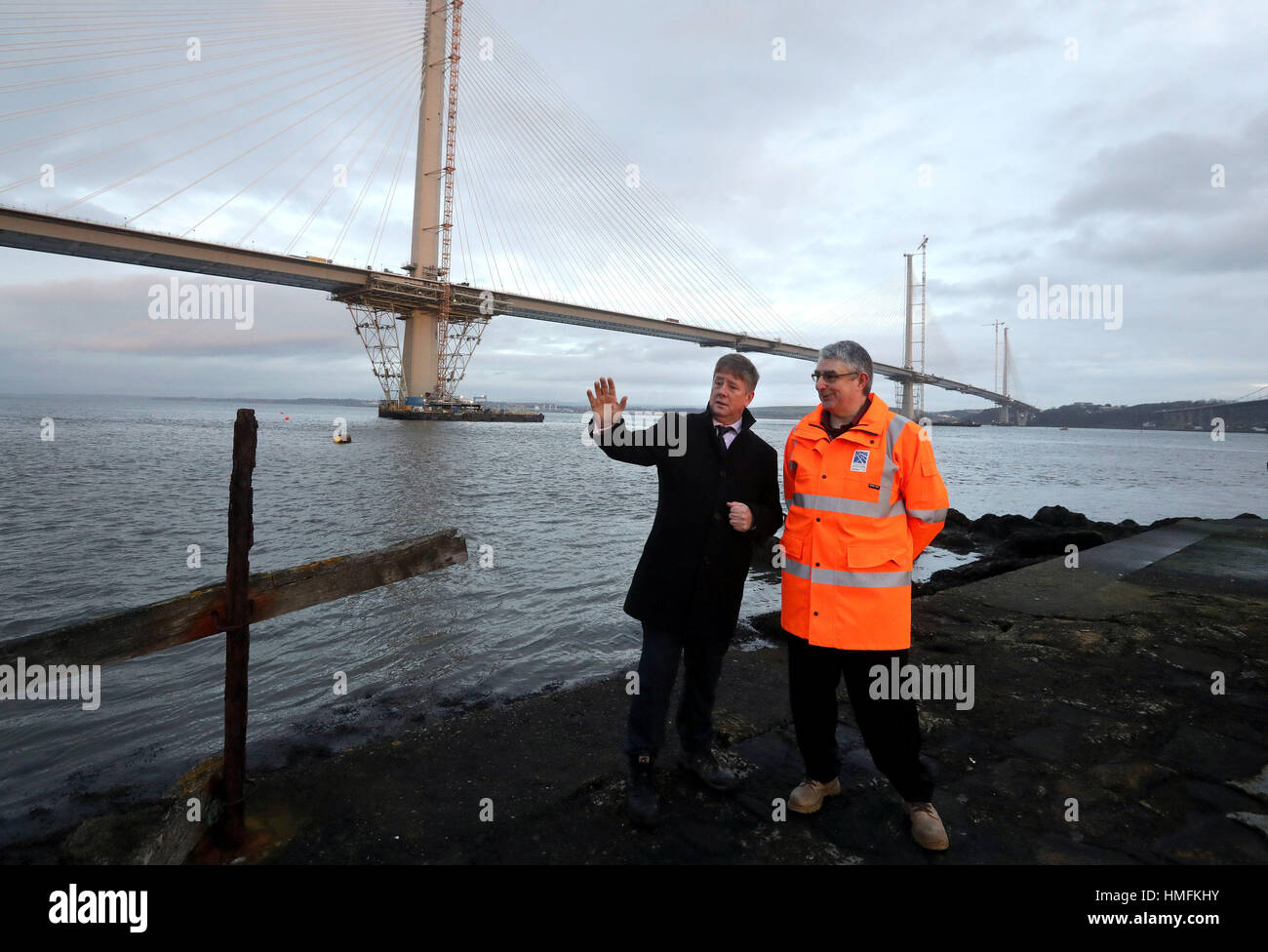 Keith Brown Economy Secretary (a sinistra) con David Climie Project Director di Transport Scotland come pezzo finale del ponte del Queensferry Crossing si siede su una chiatta prima di essere sollevato in posizione. Foto Stock
