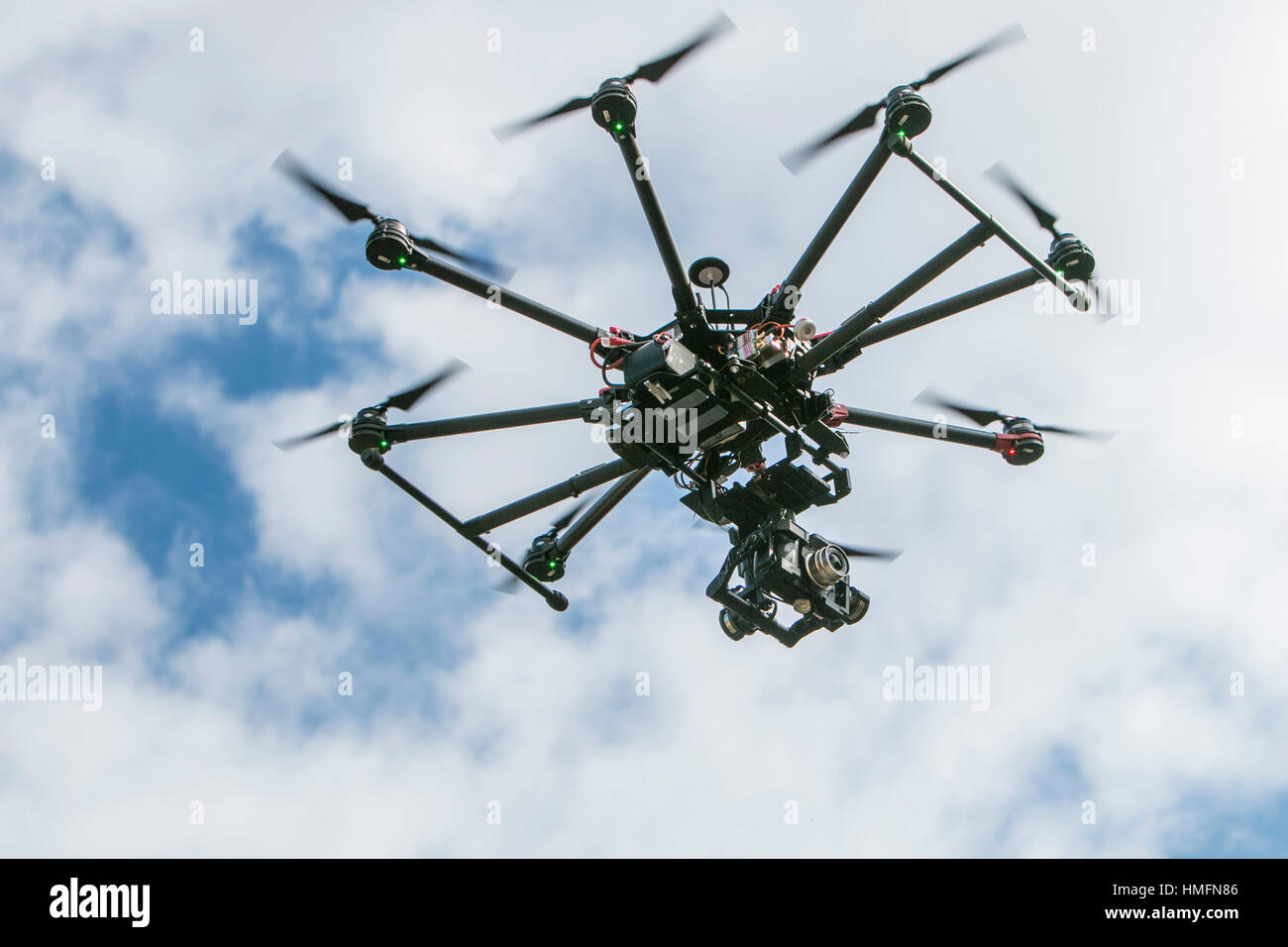Una telecamera drone in azione contro un cielo nuvoloso Foto Stock