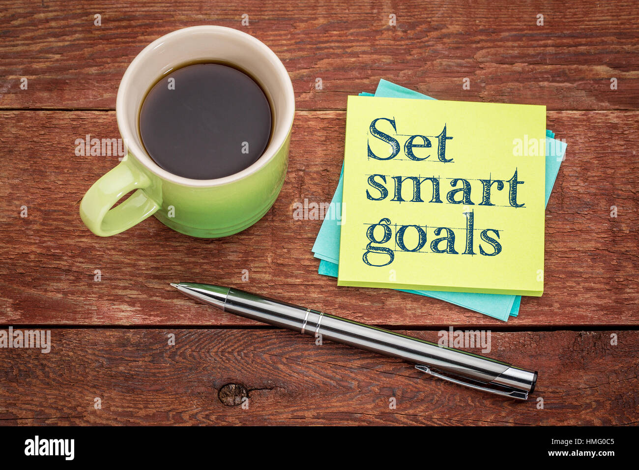 Impostare gli obiettivi smart - scrittura su una nota adesiva con una tazza di caffè Foto Stock