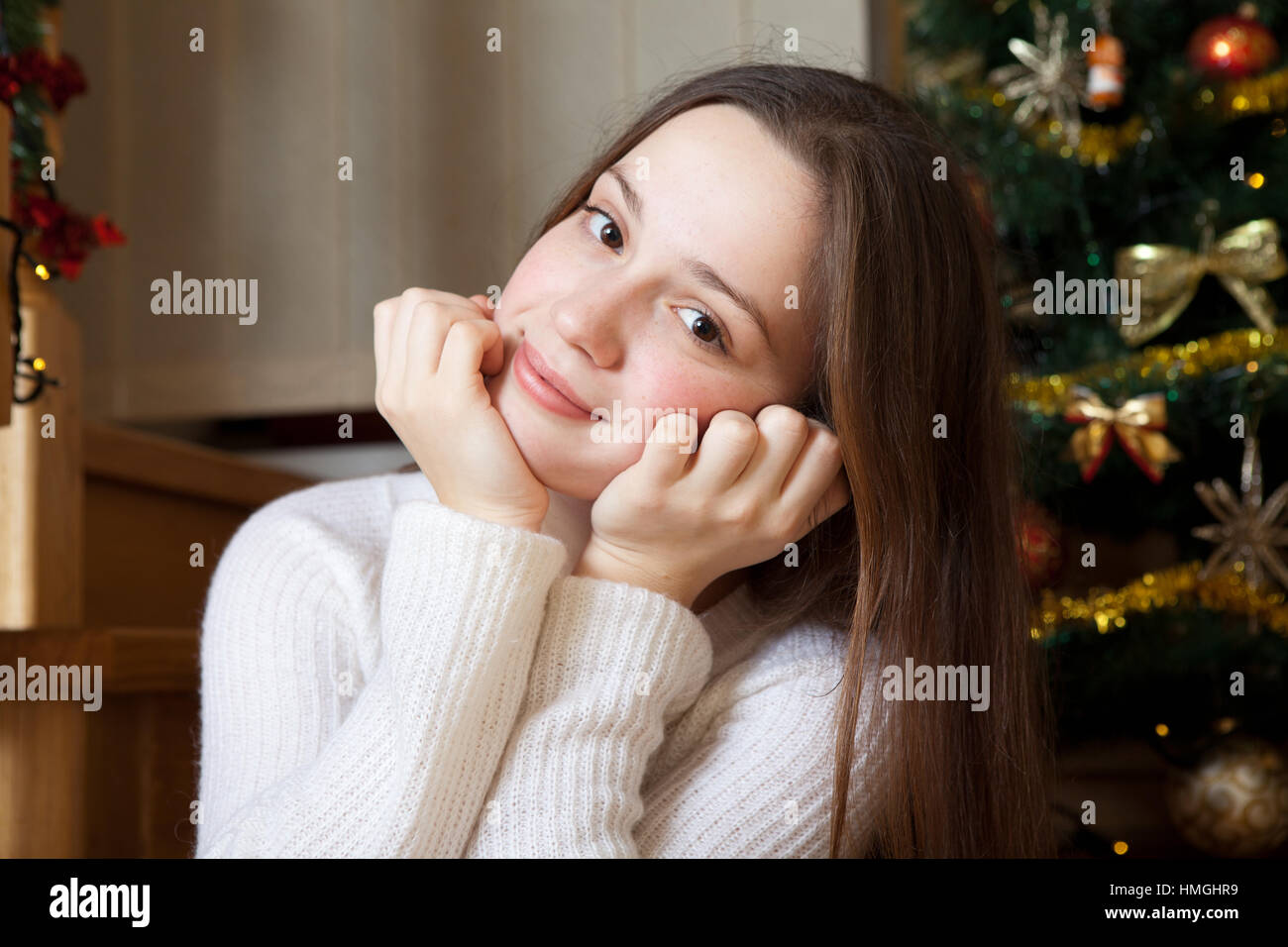 X-mas, vacanze invernali e concetto di persone - felice giovane donna decorazione di albero di natale con sfera a casa Foto Stock