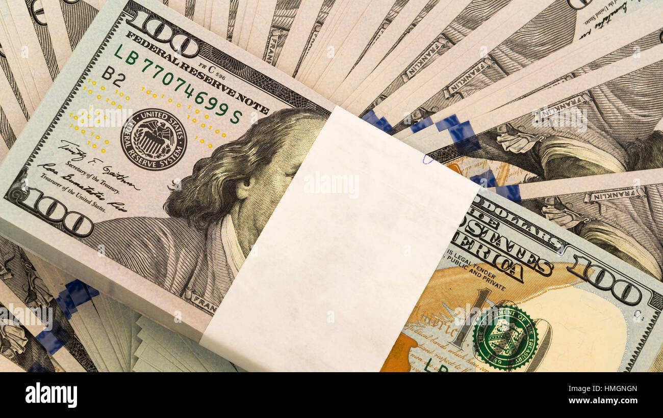 Pila di soldi in dollari in contanti in centinaia di fatture del dollaro Foto Stock