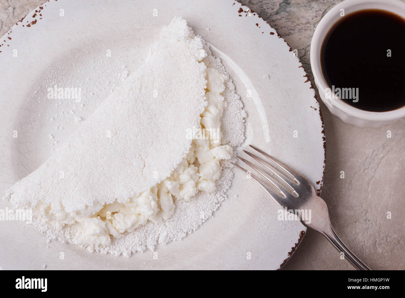 Casabe (ingaggiami, beiju, bob, biju) - flatbread di manioca (tapioca) con ricotta e miele e la tazza di caffè. Messa a fuoco selettiva Foto Stock