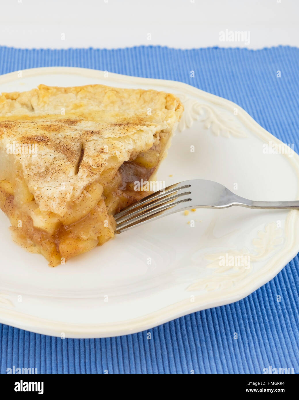 Una fetta di fatti in casa torta di mele su una piastra bianca, blu posto mat. Stati Uniti d'America. Foto Stock
