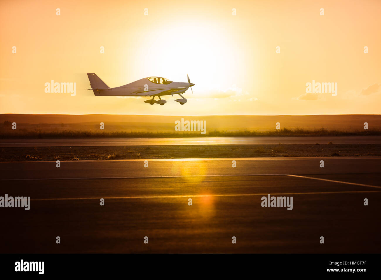 Piccolo aereo sulla pista sullo sfondo di sunrise Foto Stock