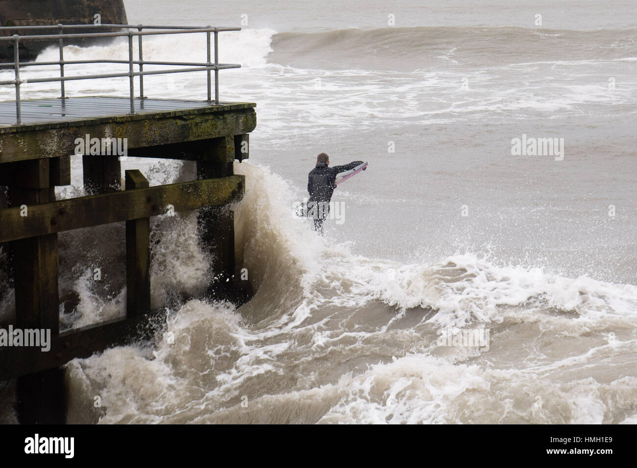 Aberystwyth, Ceredigion, Wales, Regno Unito. 3 febbraio, 2017. Regno Unito Meteo. Alta Marea e un forte rigonfiamento Atlantico questa mattina portare enormi onde che si schiantano nella passeggiata a mare e difese in Aberystwyth sulla West Wales coast. Un coraggioso corpo-boarder prende l'opportunità di cavalcare alcuni degli enormi 10' alte onde che si rompono vicino a Aberystwyth harbour potenzialmente dannosa gales, con raffiche in eccesso di 60mph sono previsioni per colpire parti del sud del Regno Unito oggi Photo credit: Keith Morris/Alamy Live News Foto Stock