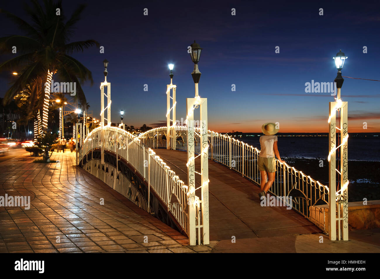 Donna illuminata a piedi il ponte e bay, Malecon (lungomare), La Paz, Baja California Sur, Messico Foto Stock