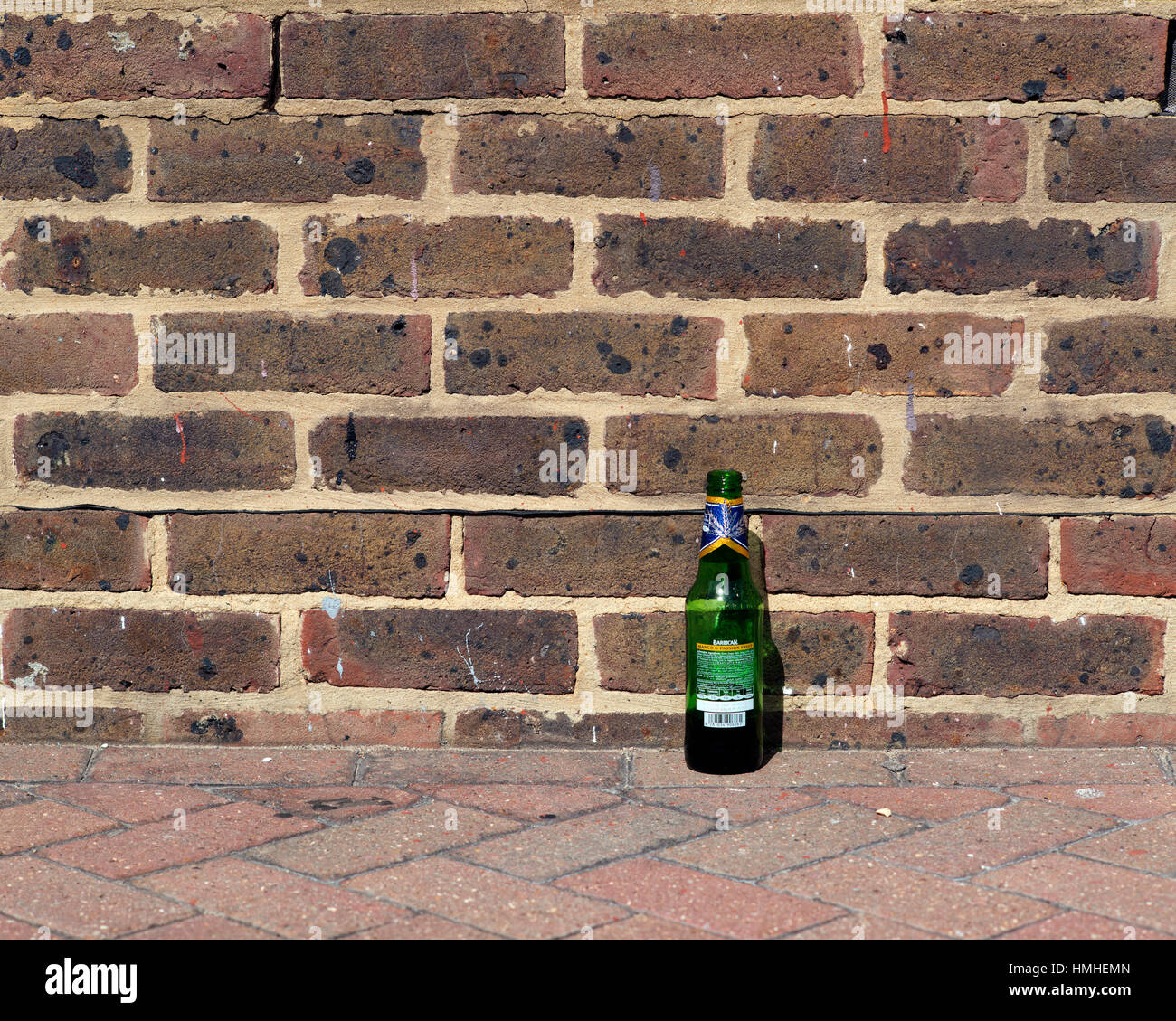 Bottiglia vuota a sinistra da un muro, London, Regno Unito Foto Stock