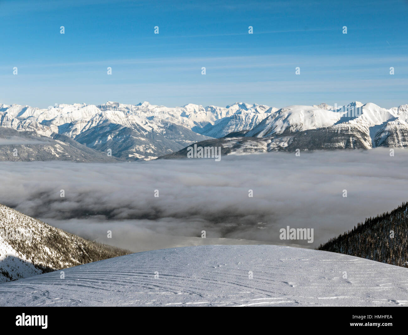 Innevato paesaggio di montagna con la nebbia riempito della valle; Esplanade gamma; Selkirk gamma; British Columbia; Canada Foto Stock