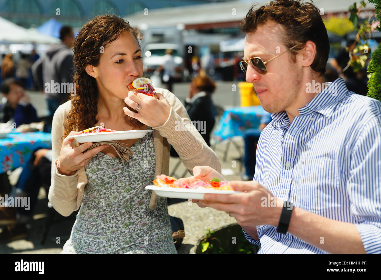 Vista ravvicinata di una giovane coppia di mangiare cibo di strada di San Francisco, California Foto Stock