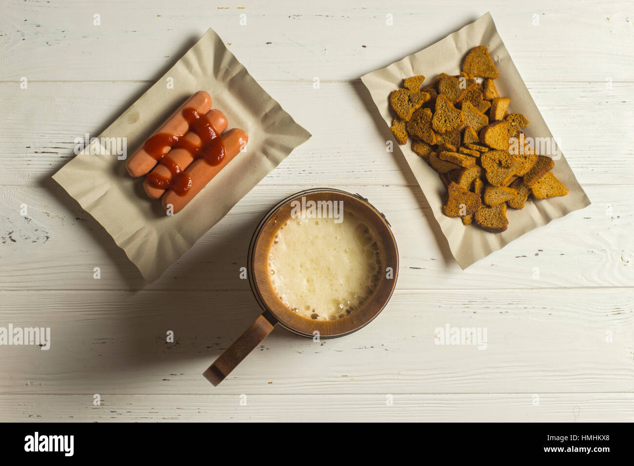 Boccale di birra, salsicce e pane secco su sfondo di legno Foto Stock