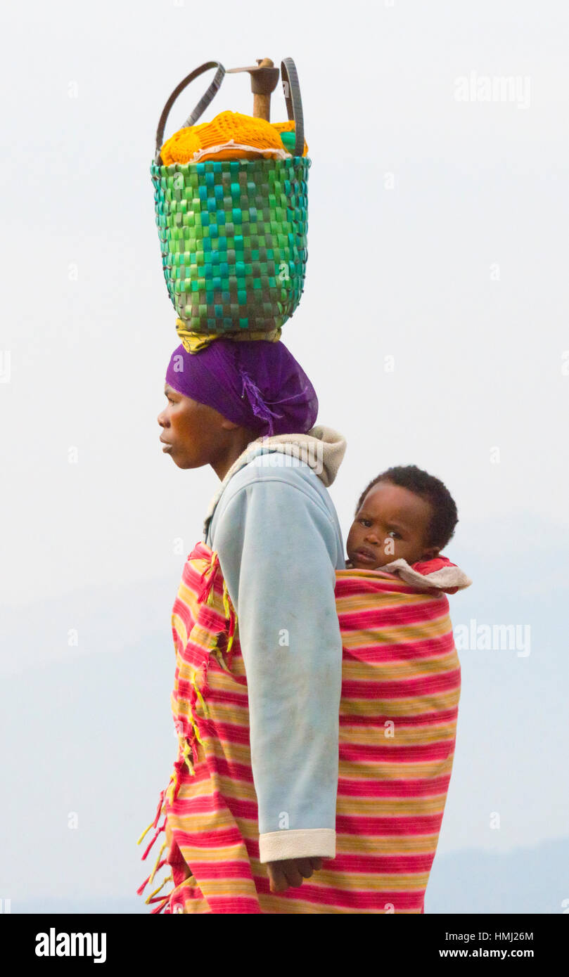 Donna cestello di trasporto sulla testa, Ruanda Foto Stock