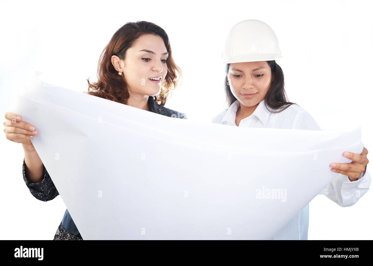 Due donna ingegnere guardare in piani isolato su bianco Foto Stock