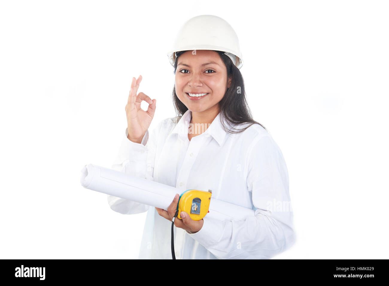 Contraente ragazza con casco bianco e i piani di contenimento ed il misuratore mostra gesto ok Foto Stock